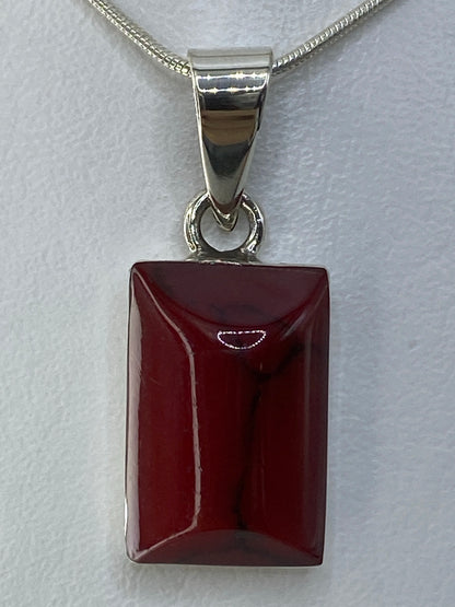 Dije de plata 950 rectangular con piedra roja engastada, suspendido en cadena de plata