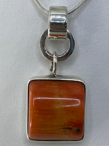 Dije cuadrado de plata 925 con piedra naranja engastada, colgando de cadena de plata