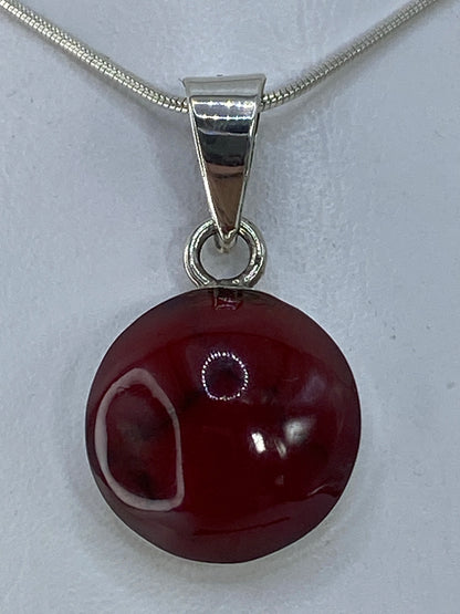 Dije de plata 950 con piedra roja redonda, colgado de cadena serpentín