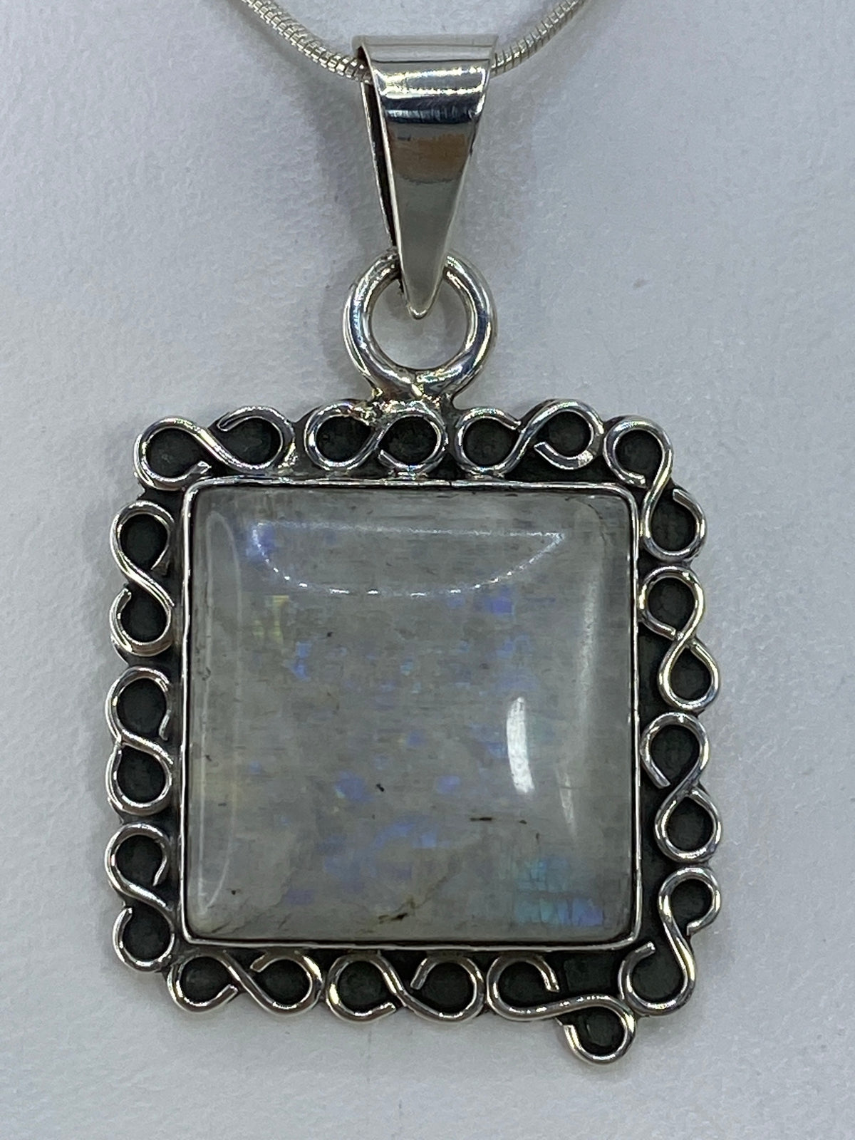 Dije de plata 925 con ópalo de fuego multicolor, vista frontal mostrando tonos rojos, naranjas y verdes