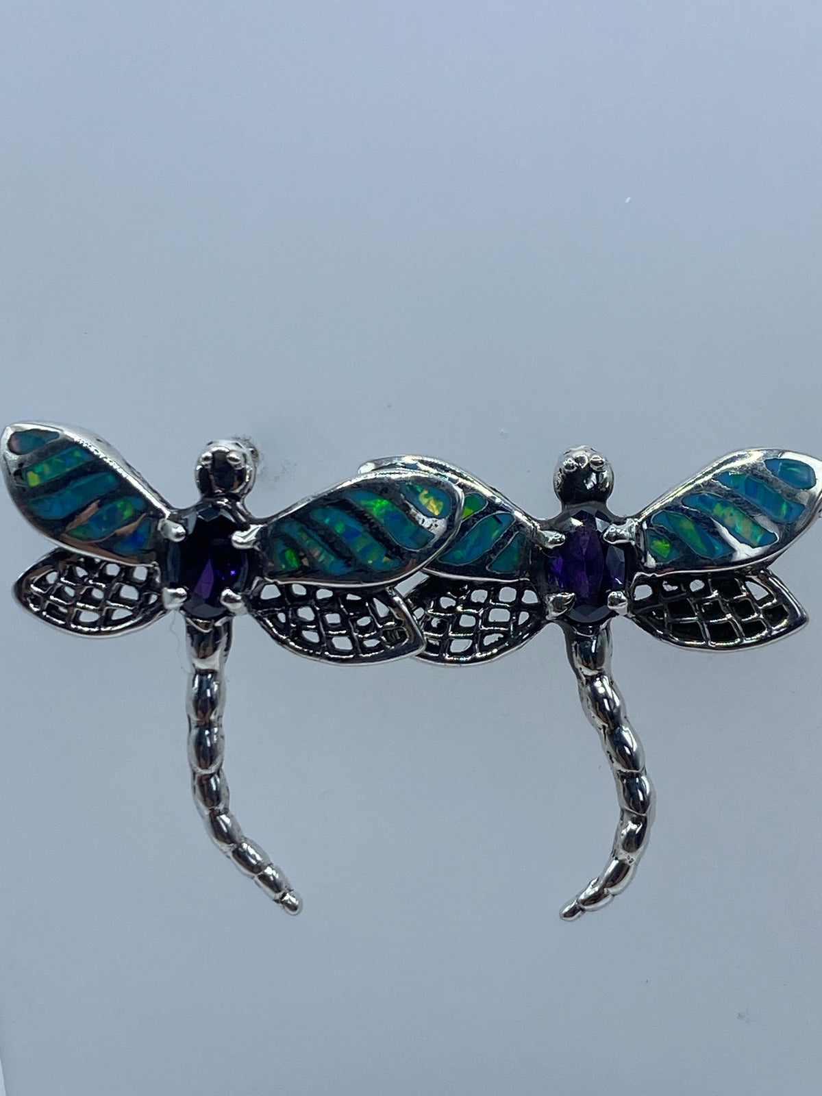 Aretes libélula de plata 950 sobre fondo blanco mostrando las alas caladas