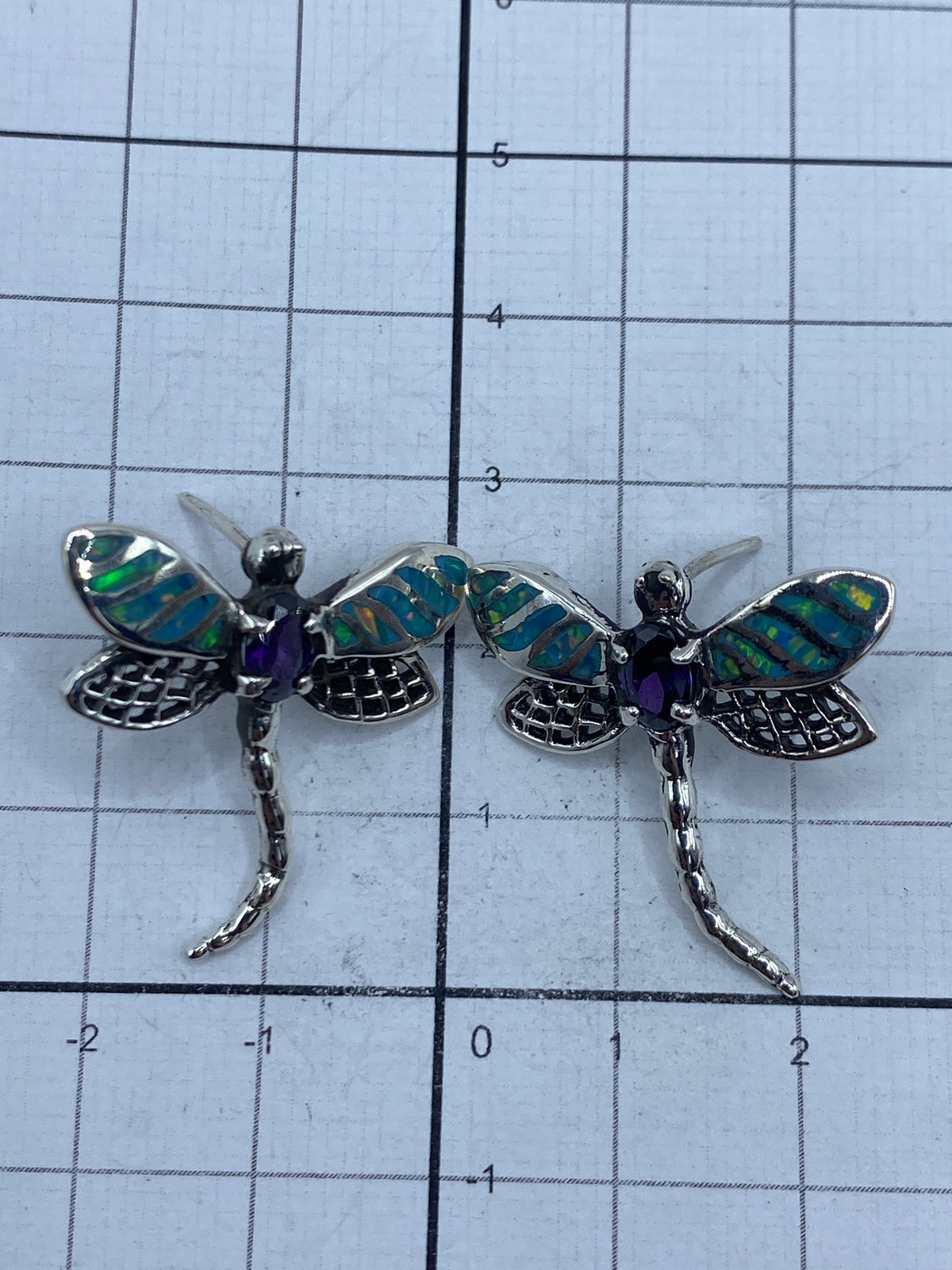 Par de aretes colgando con ópalo de fuego que refleja luz azul y verde