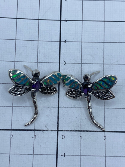 Par de aretes colgando con ópalo de fuego que refleja luz azul y verde