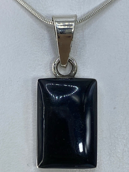 Detalle lateral del dije de plata 950 con engaste limpio y ónix pulido