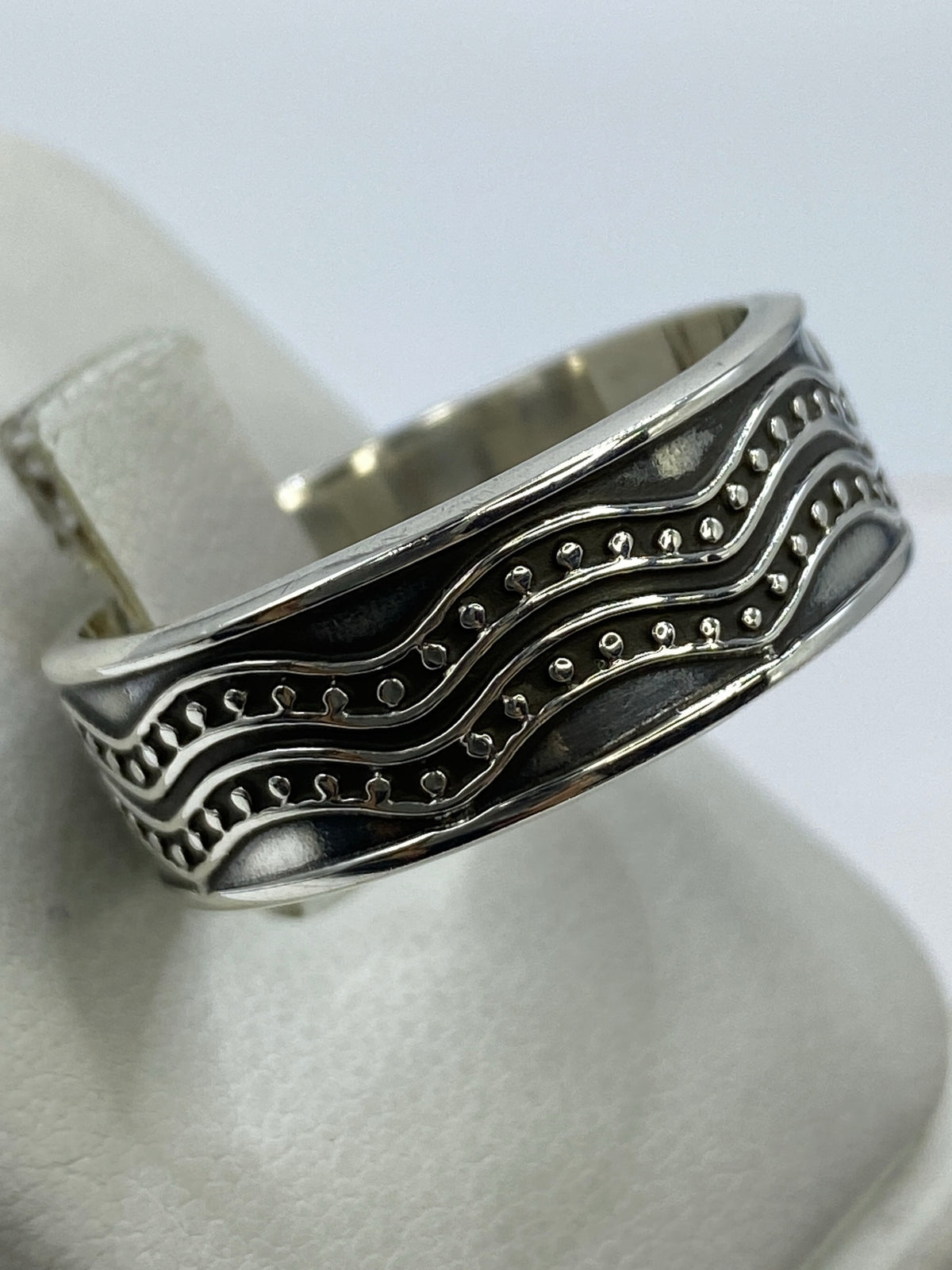 Anillo en la mano mostrando el contraste entre el pulido y la textura mate del repujado