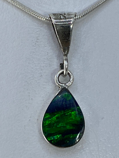 Detalle del Ópalo de Fuego verde con reflejos en el engaste de plata