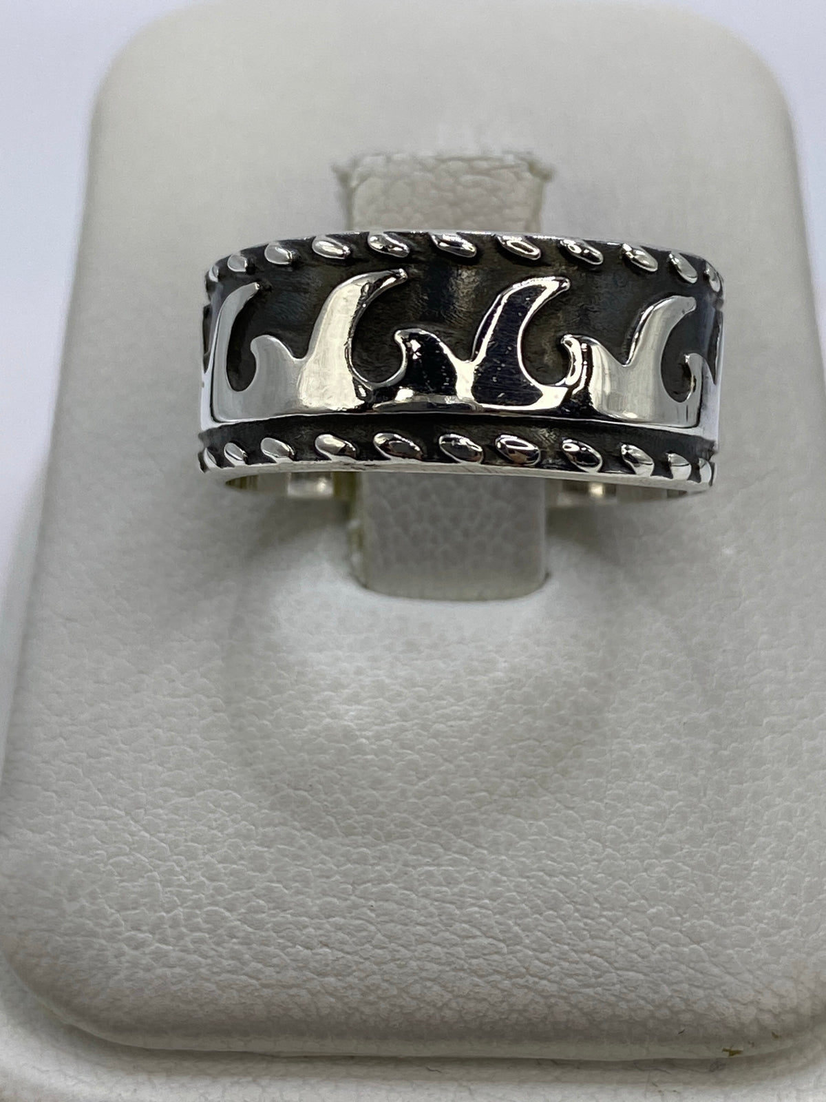Anillo de plata repujado con diseño de olas en la mano