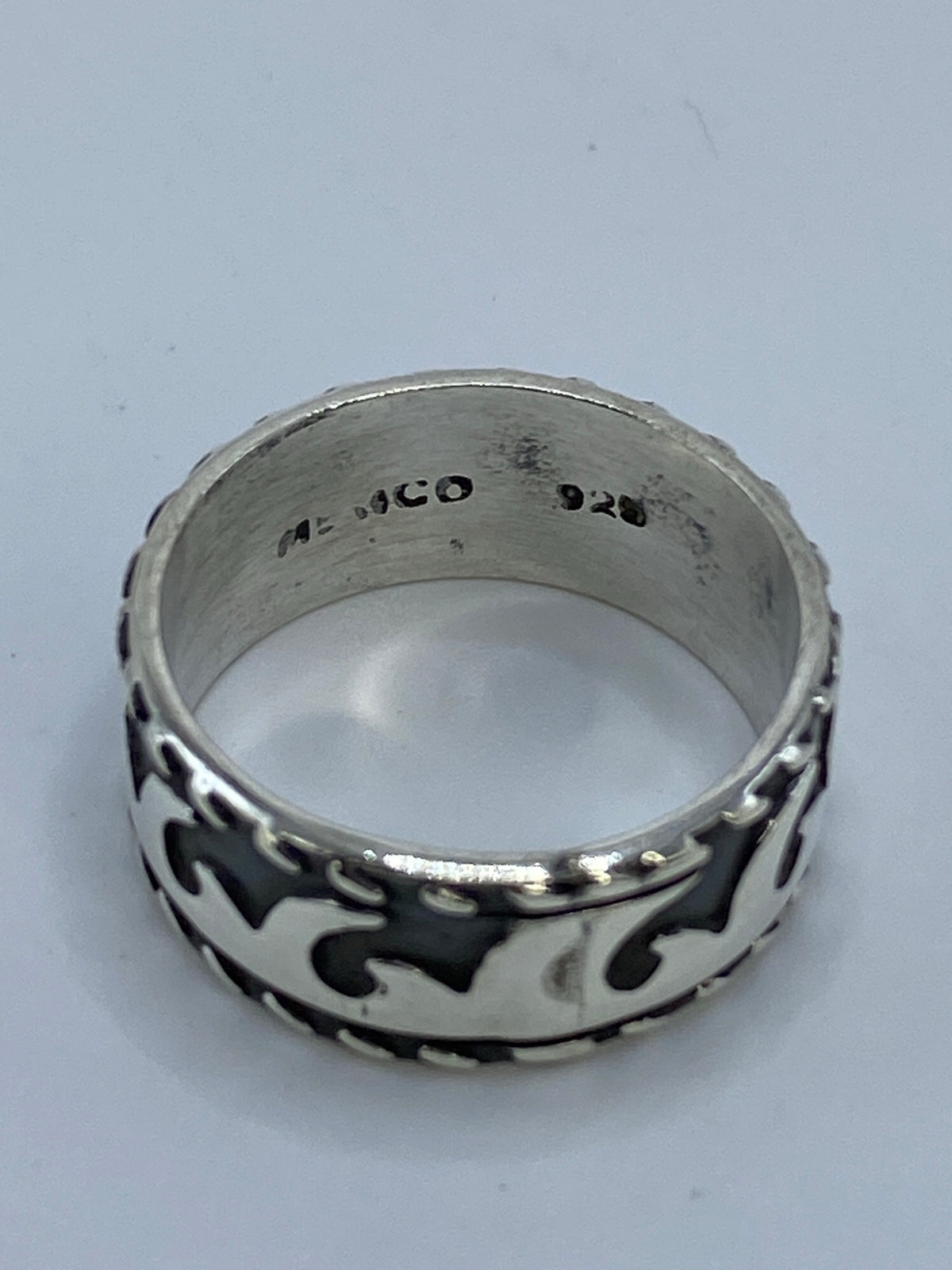 Anillo de plata sobre fondo blanco mostrando el patrón de olas