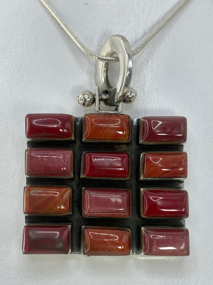 Dije de plata 925 con incrustación multicolor en tonos rojo, naranja, violeta y vino