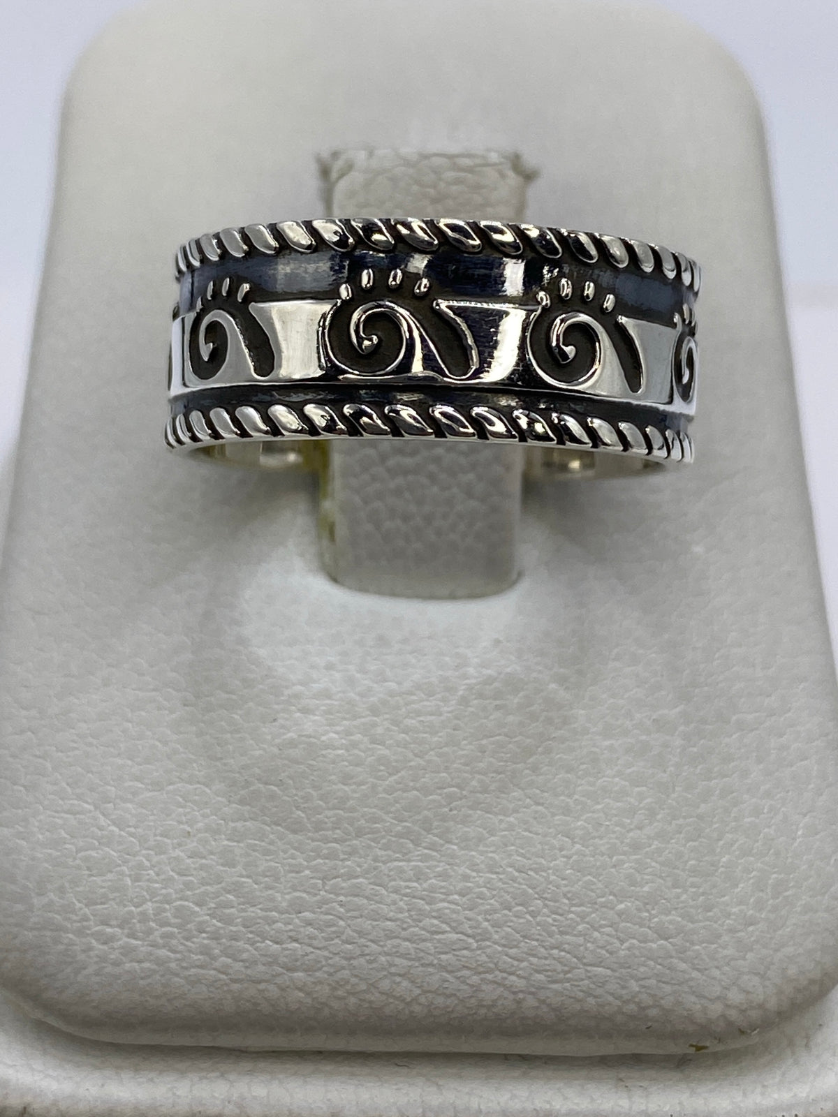 Anillo de plata 925 repujado con motivos geométricos étnicos en la mano de un hombre