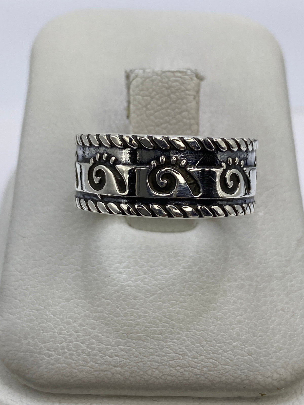 Anillo de plata repujado con espirales prehispánicas sobre anillo blanco