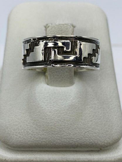 Anillo de plata repujado con diseño prehispánico geométrico, visto de frente en blanco