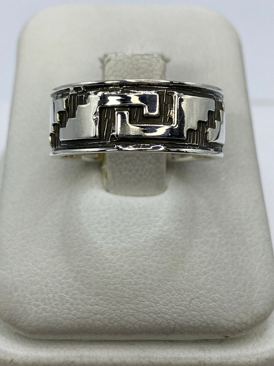 Anillo de plata repujado con diseño prehispánico geométrico, visto de frente en blanco