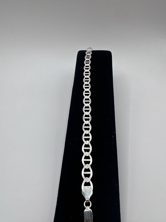 Pulsera de eslabón en plata .925 sobre fondo negro, mostrando el diseño de eslabones lisos y simétricos