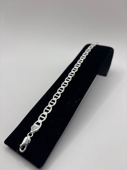 Detalle de los eslabones de la pulsera de plata, vista lateral sobre exhibidor
