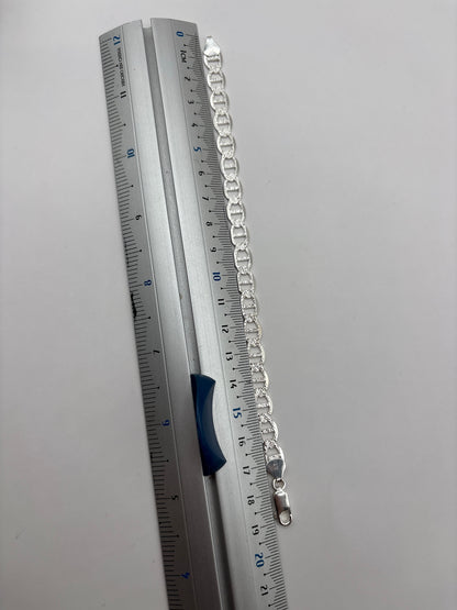 Pulsera de eslabón en plata puesta en muñeca, luciendo elegante y versátil