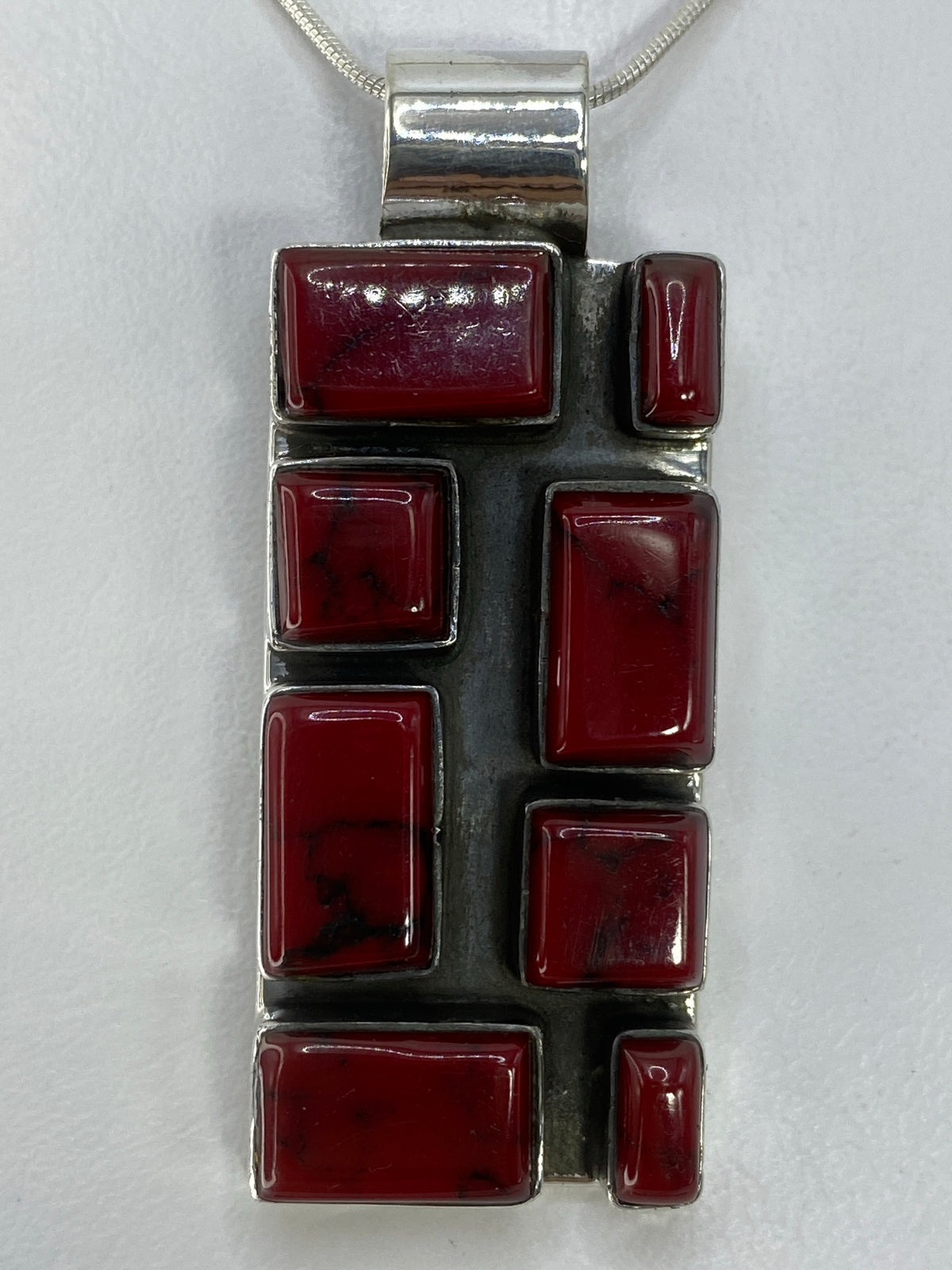 Reverso pulido del dije de plata 950 mostrando la marca del Quinto