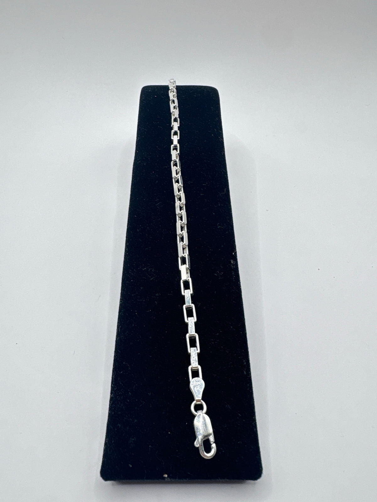 Pulsera de eslabón en plata .925 de Taxco, largo 18 cm, exhibida en forma vertical sobre presentador negro