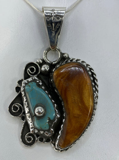 Dije de plata con turquesa azul cielo engastada, detalle frontal mostrando la piedra natural y los detalles en espiral