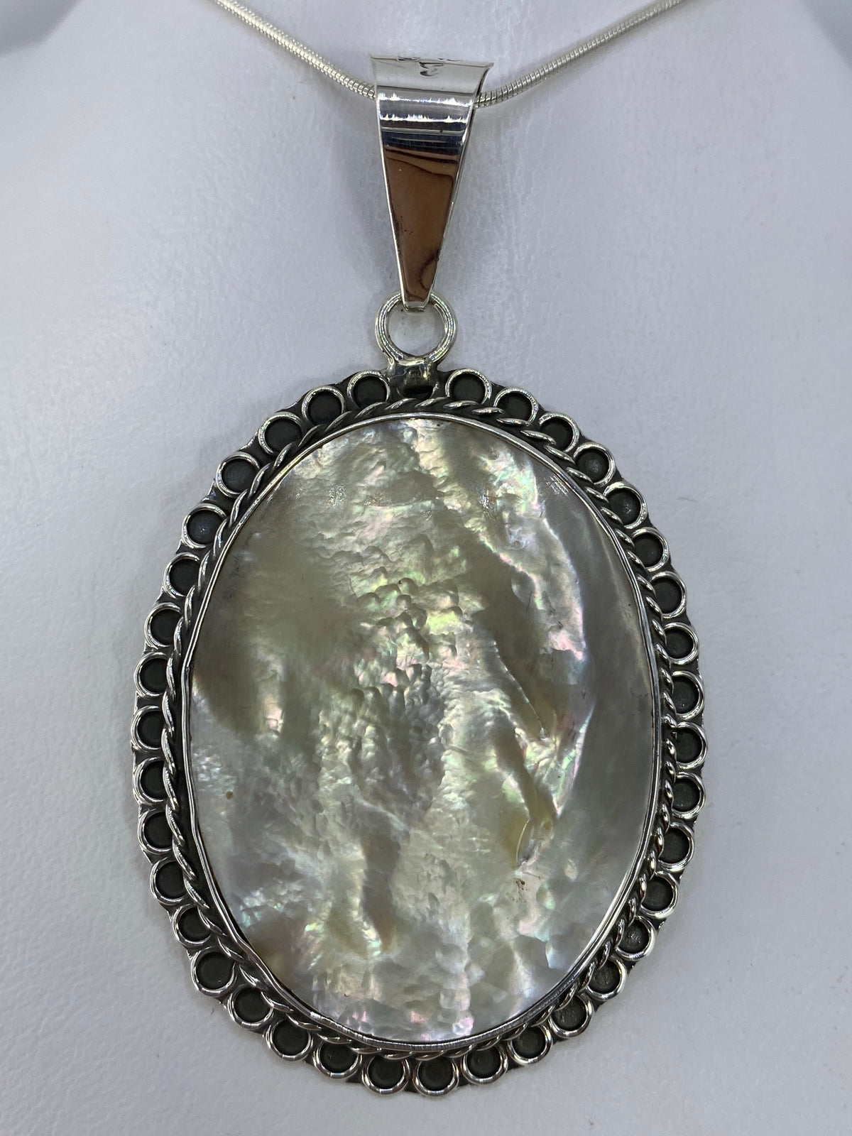Dije de plata 950 con perla blanca engastada en marco art-déco de Taxco, colgando de cadena