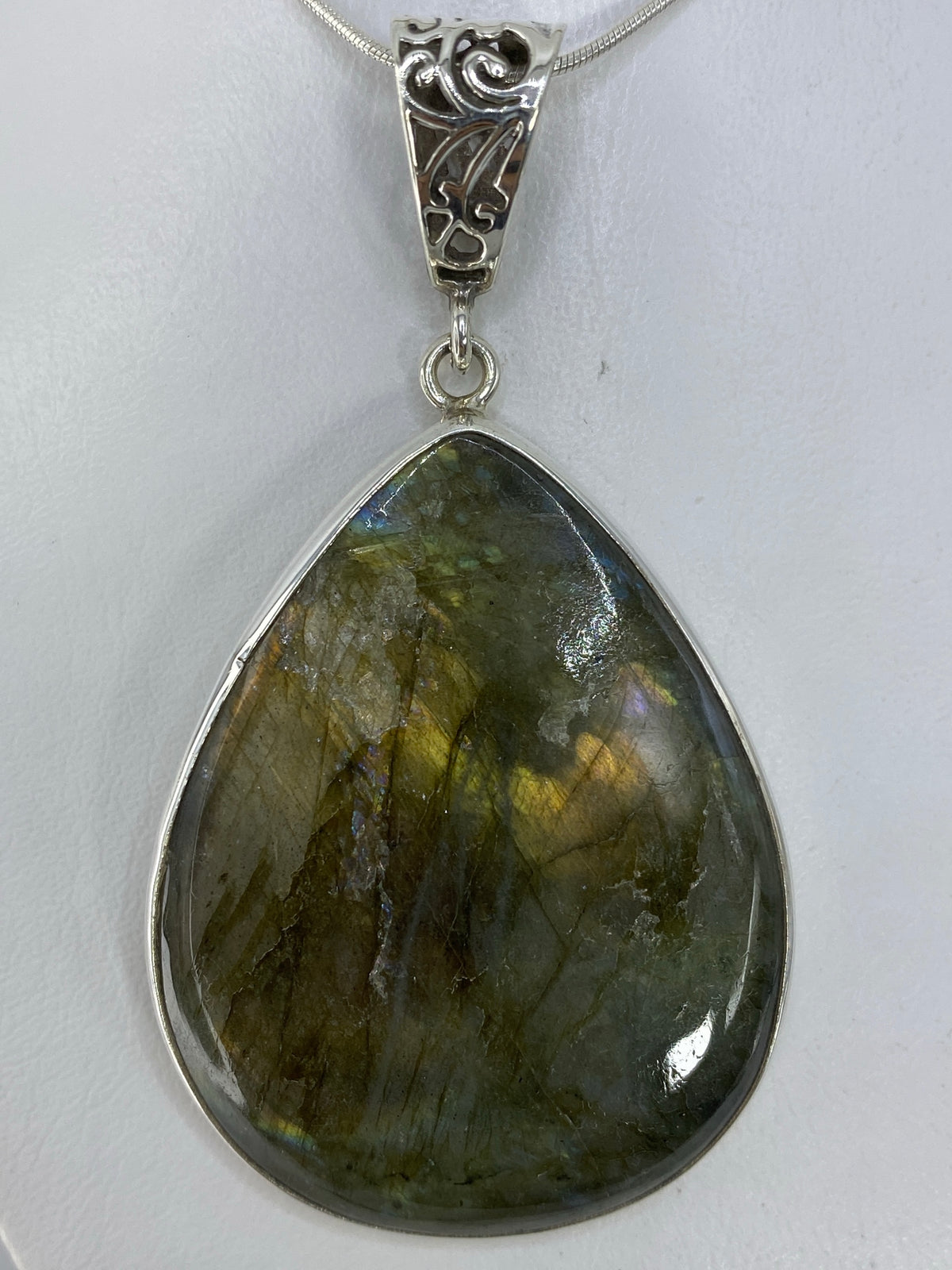 Dije con piedra natural sobre fondo blanco mostrando el Quinto 925