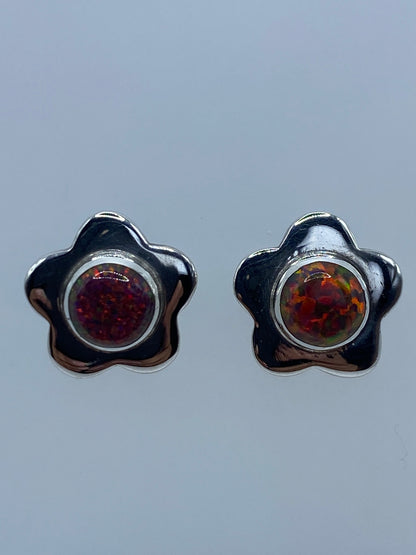 Par de aretes de plata 950 con ópalo de Fuego multicolor en forma de flor sobre fondo gris