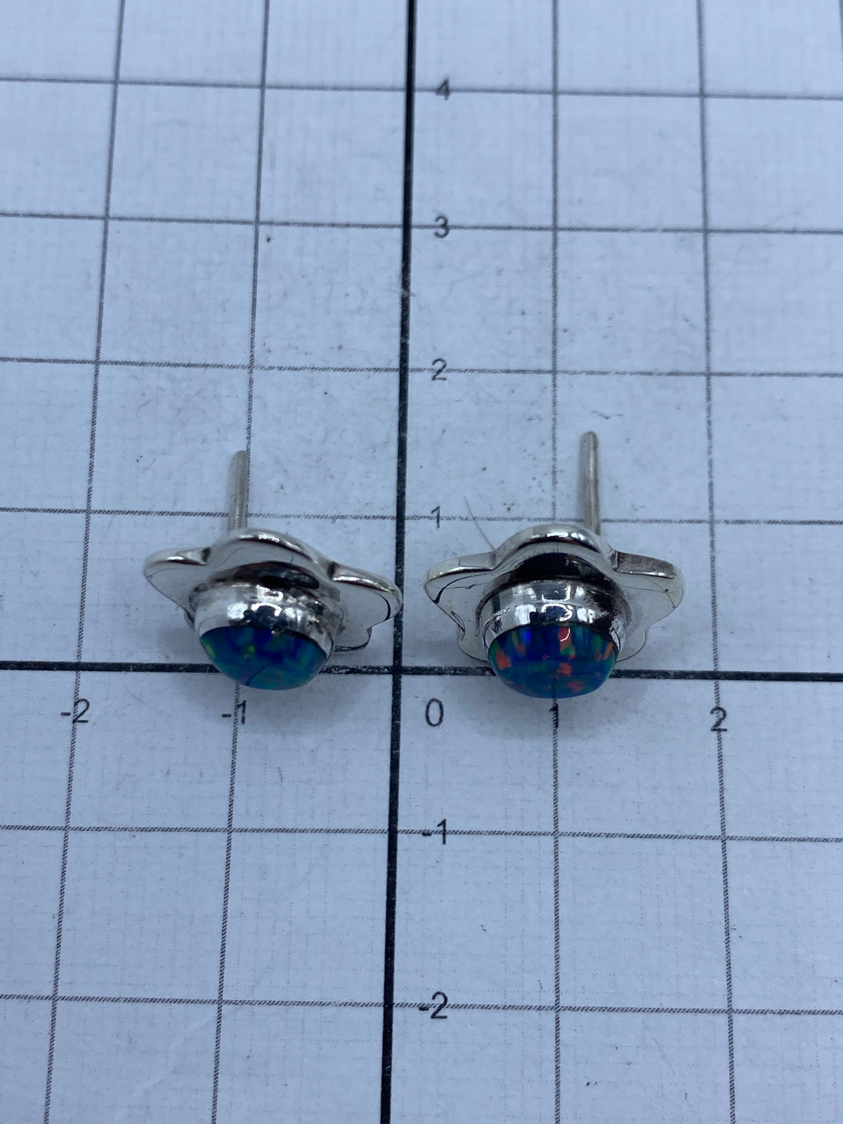 Reverso de los aretes mostrando el sello 950 y el cierre de mariposa