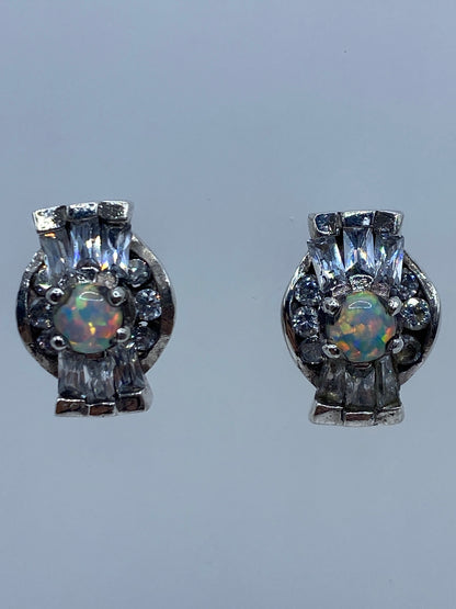 Par de aretes de plata 925 con ópalo de fuego multicolor, vistos de frente en fondo gris
