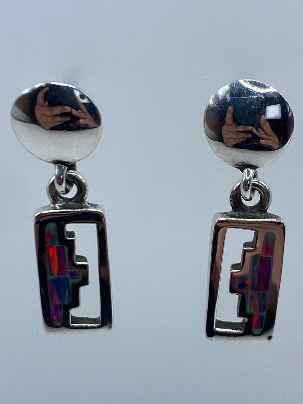 Detalle de un arete mostrando el ópalo de fuego azul engastado en plata 950
