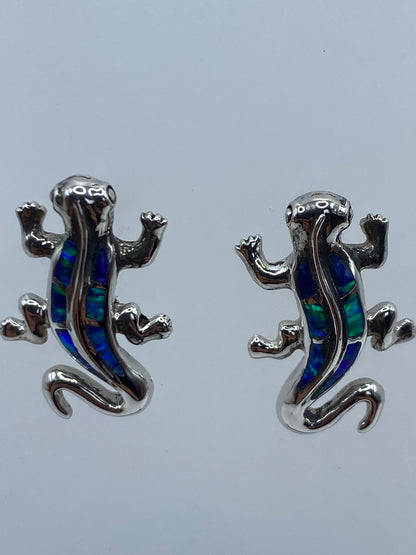 Aretes de plata con ópalo sobre fondo gris mostrando el Quinto