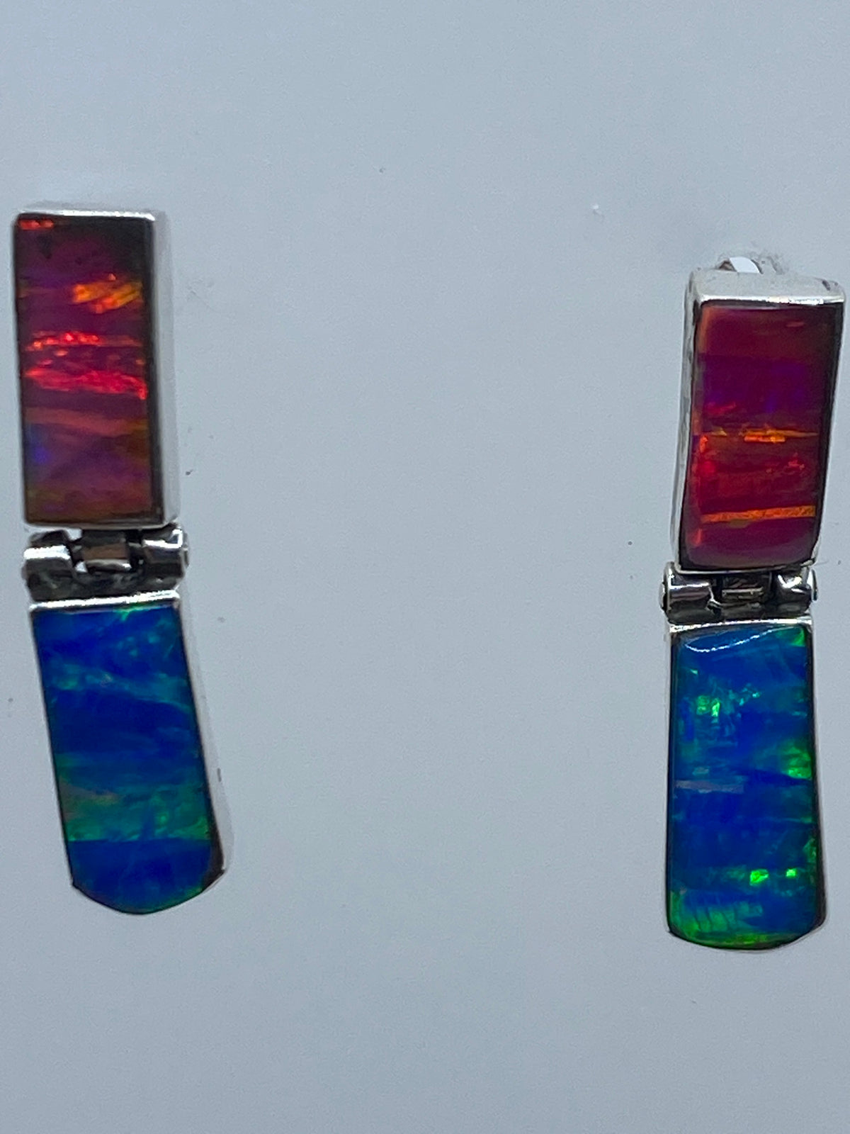 Aretes de plata 925 con incrustación de ópalo de fuego, mostrando los colores rojo, naranja y azul