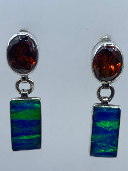 Aretes puestos en la oreja, ópalo azul reflejando luz natural