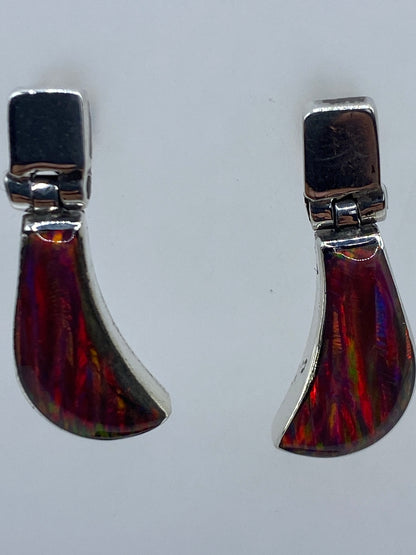 Aretes de plata 950 engastados a mano, vista frontal mostrando el brillo del ópalo de fuego