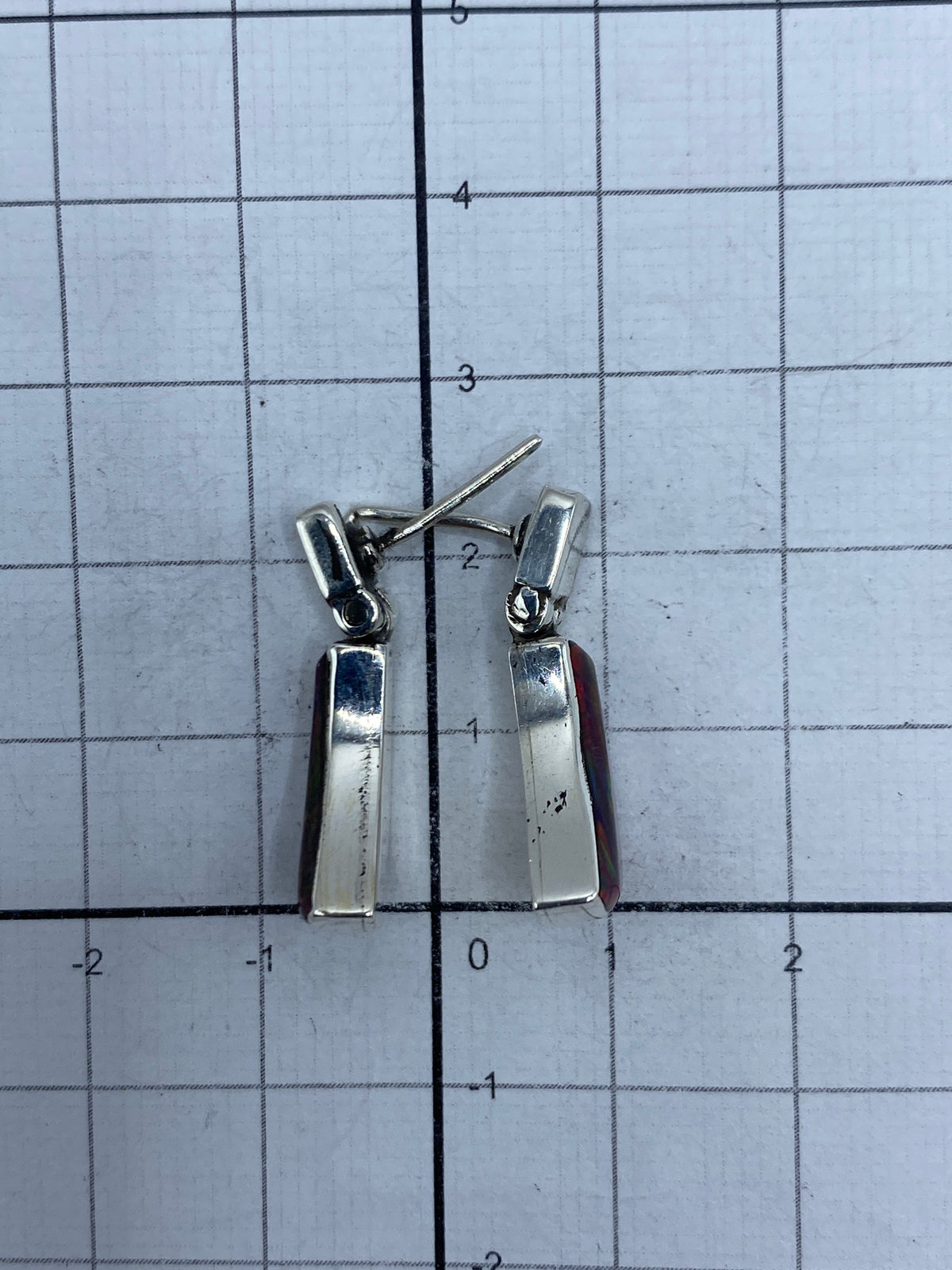Aretes colocados lado a lado en regla de medida, largo 2.3 cm