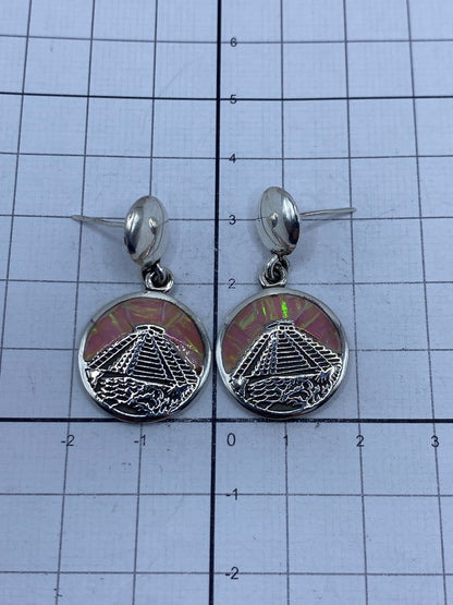 Aretes sobre fondo gris mostrando el brillo de la plata 950 y el fuego del ópalo