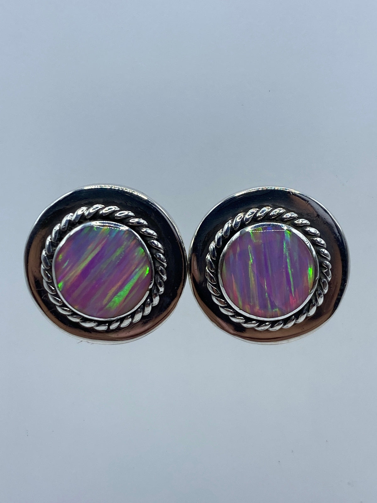 Par de aretes de plata 950 con ópalo de fuego morado engastado a mano, sobre fondo blanco