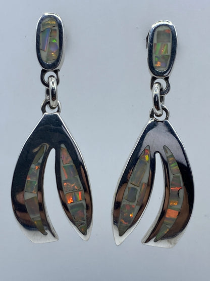 Par de aretes de plata 950 con ópalo de fuego multicolor en postes, mostrando el juego de colores naranjas y verdes