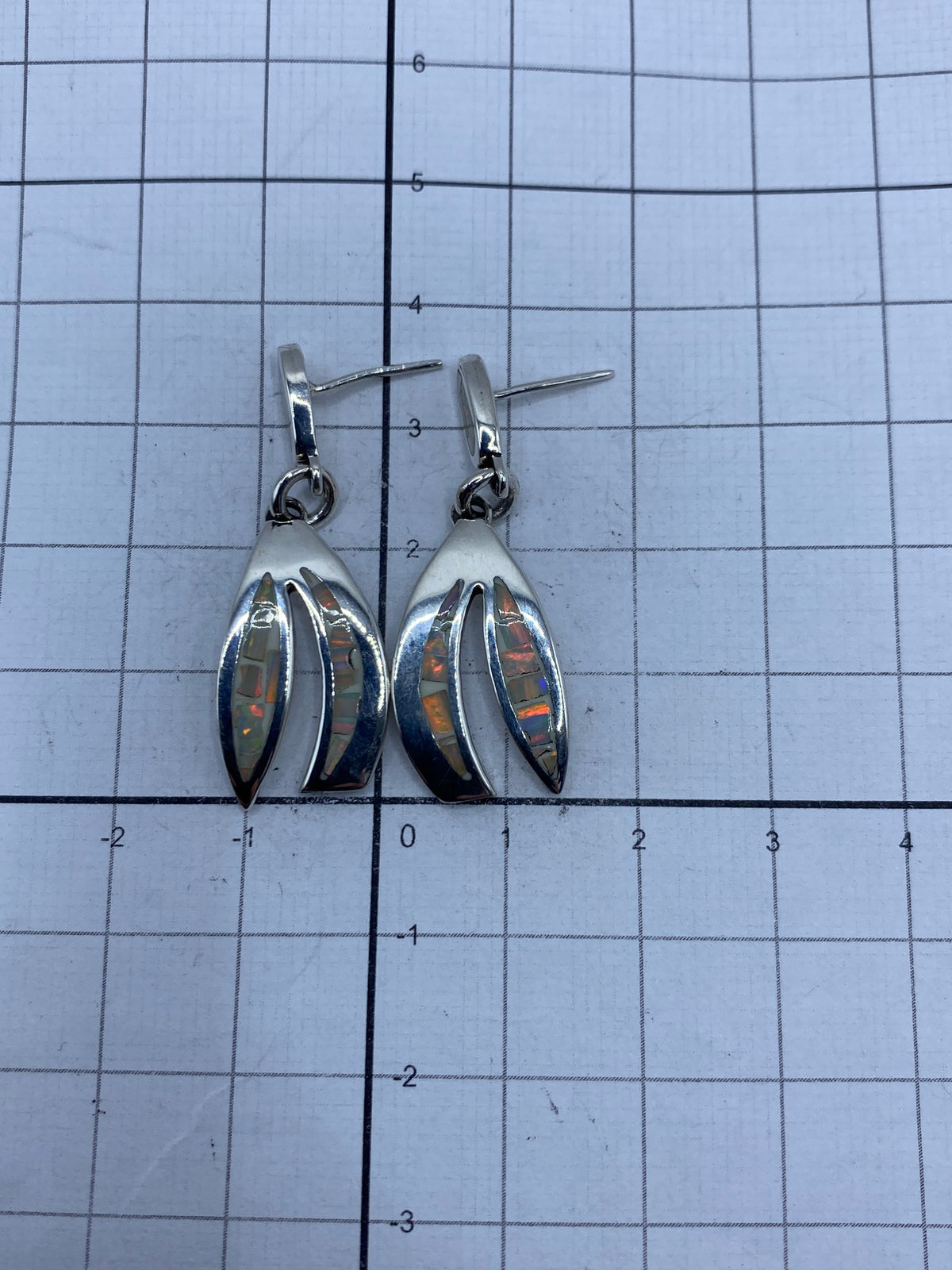 Aretes de plata 950 con ópalo de fuego sobre fondo neutro, mostrando la escala de 3.5 cm