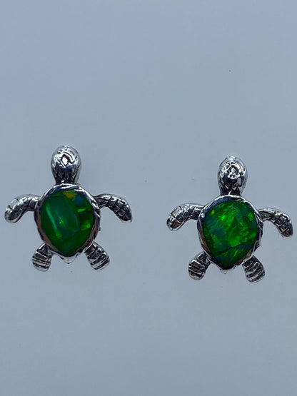 Detalle del engaste a mano del ópalo de fuego en los aretes de tortuga de Taxco