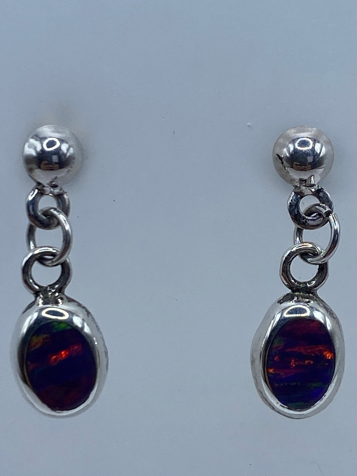 Par de aretes de plata con ópalo de fuego multicolor en tonos rojos y naranjas