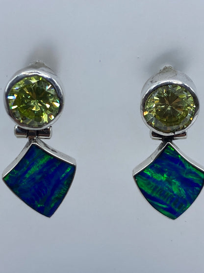 Aretes colocados sobre una regla de centímetros, mostrando 2.8 cm de largo