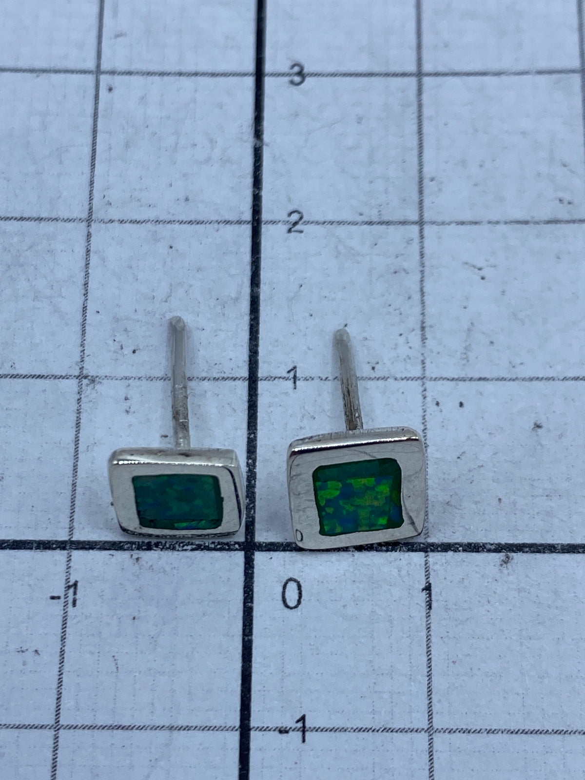 Aretes sobre fondo gris mostrando el Quinto 950 en la base