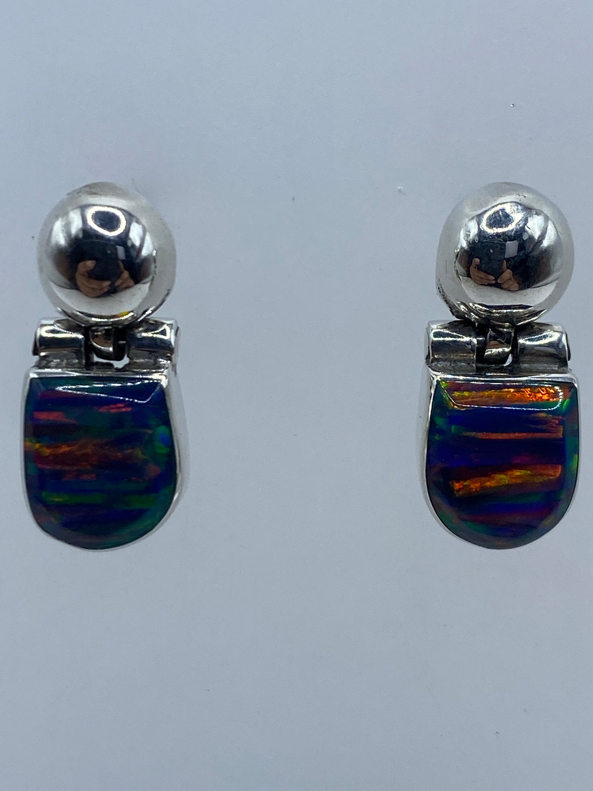 Par de aretes de plata con ópalo de fuego multicolor en tonos naranja, verde y azul