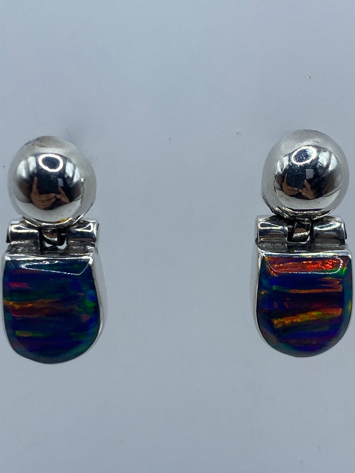 Aretes de tamaño compacto (1.9 cm) con ópalo de fuego capturando luz