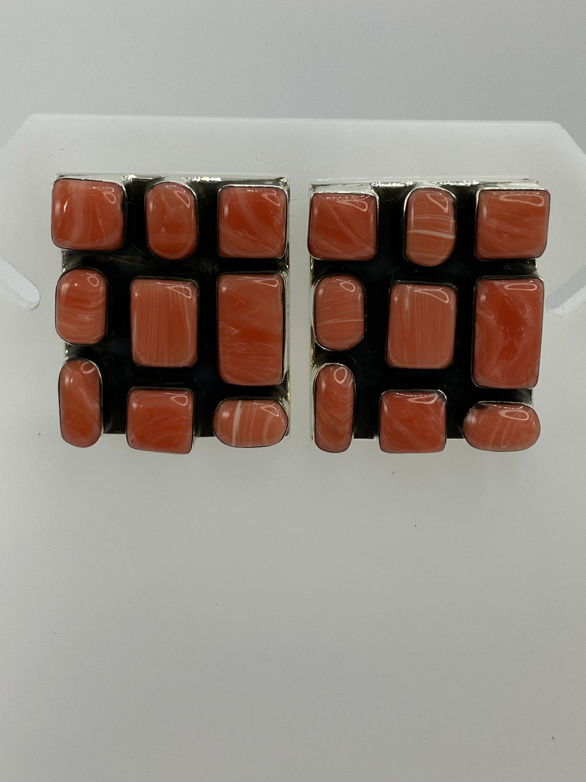 Aretes de plata 925 con coral rosa engastado, par sobre fondo blanco