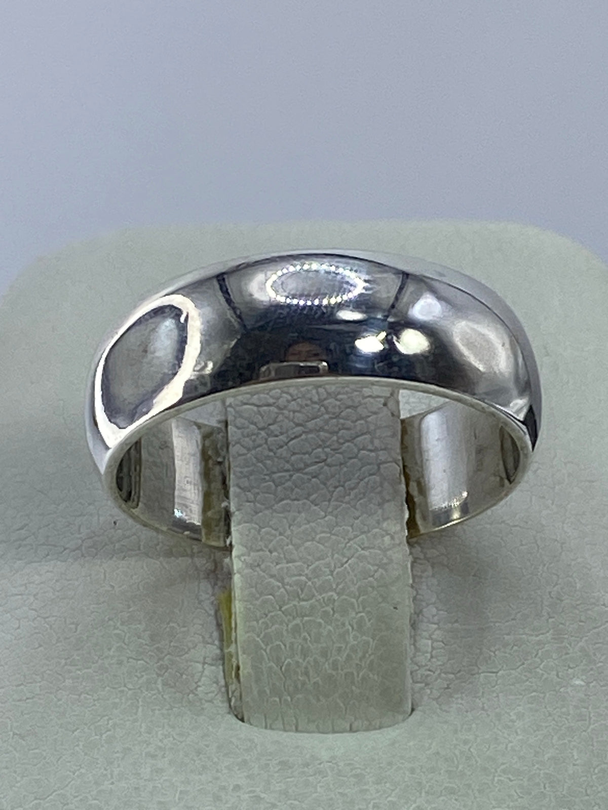 Anillo de plata clásico sobre fondo blanco mostrando el acabado brillante