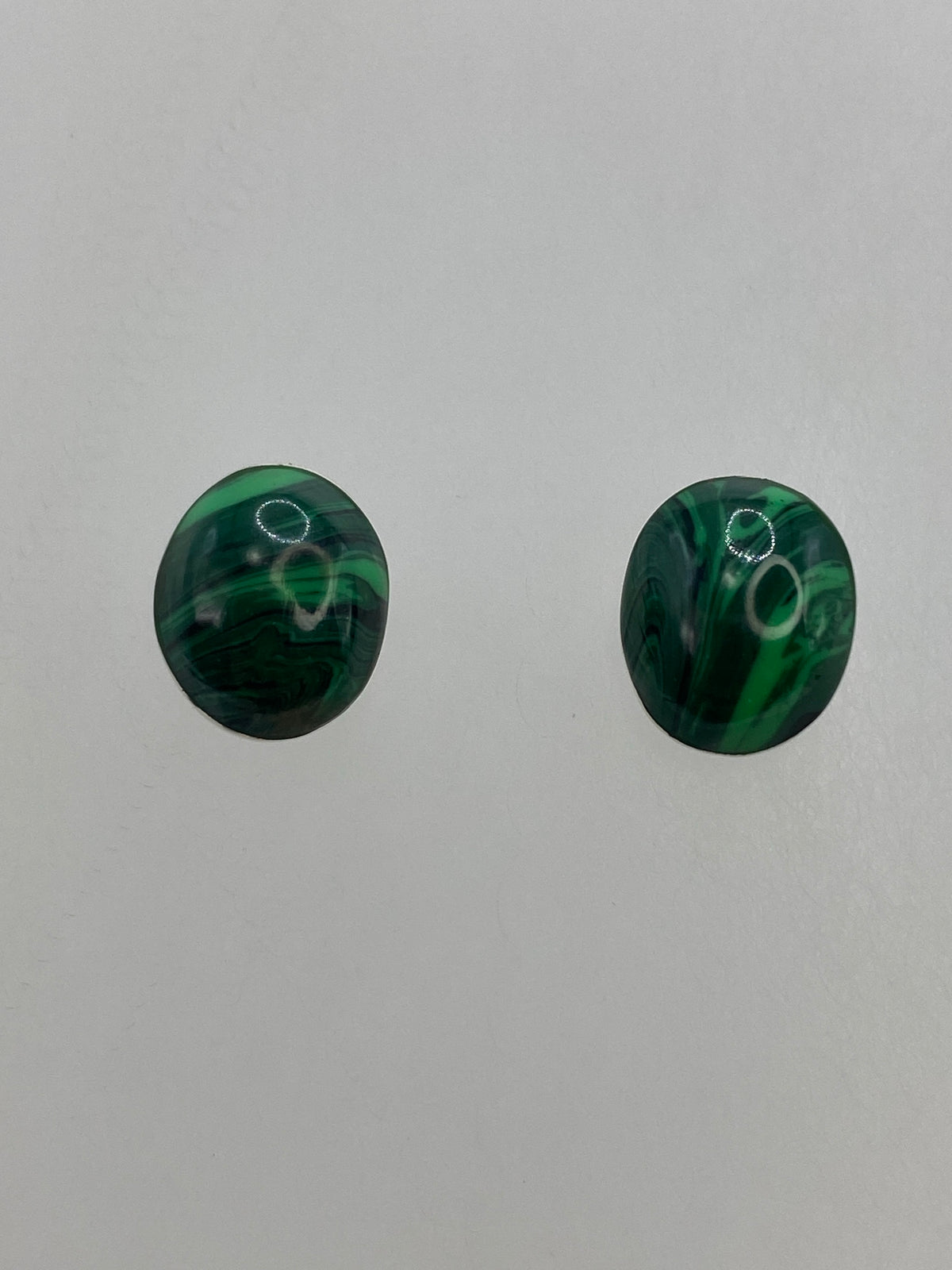 Par de aretes de plata con malaquita verde, vista frontal de los cabujones pulidos