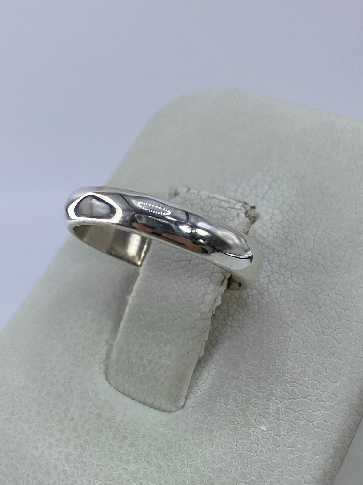 Anillo de plata pura en la mano, mostrando el brillo del pulido