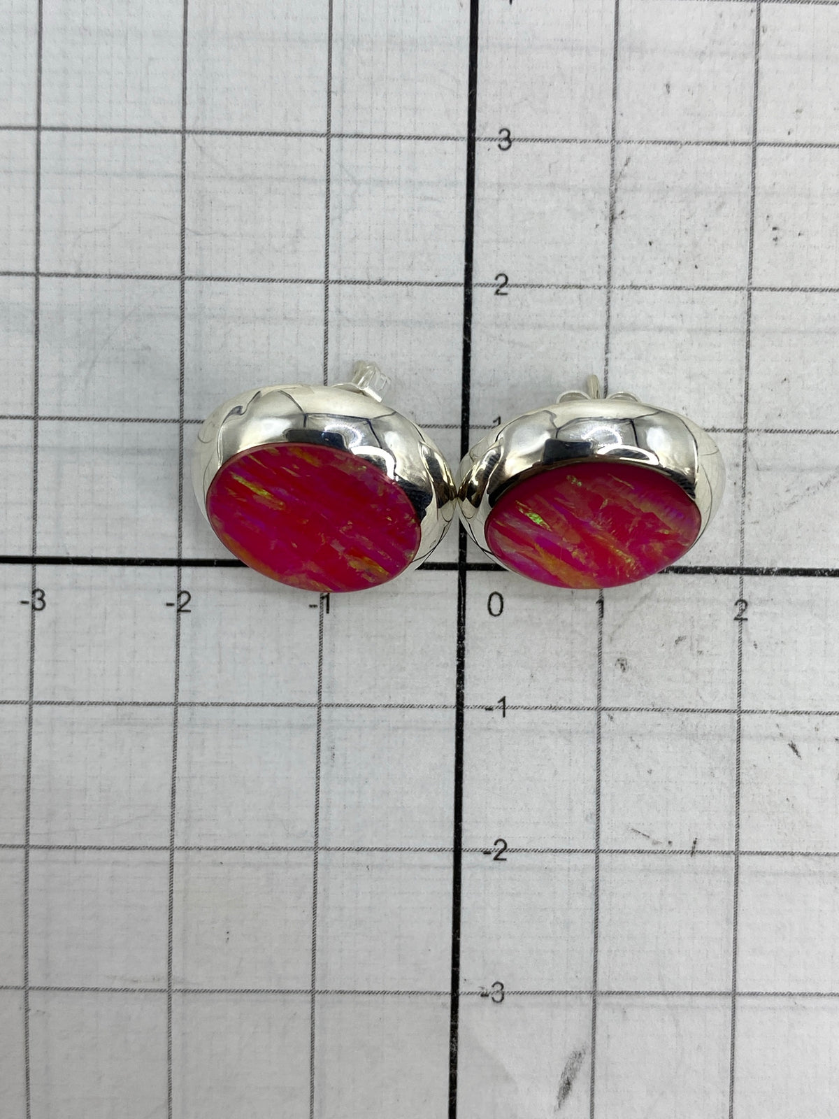 Aretes de opalo de fuego en tonos rosa puestos en modelo de orejas