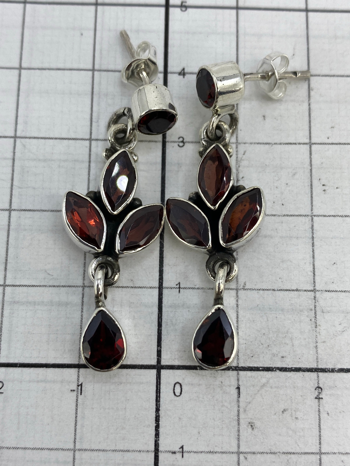 Aretes sobre fondo blanco con marca de peso 8.59 g, Quinto 925 visible